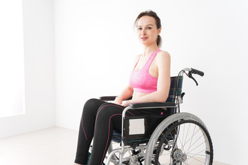 Naklejka na ściany i meble スポーツウェアを着て車椅子に乗る外国人の女性