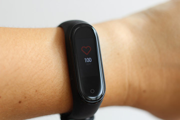 Close-up portrait of sport girl using fitness tracker or heart rate monitor