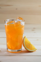 Orange Juice glass on wooden background. Pieces of orange fruit along with the glass.