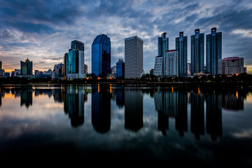 Fototapeta premium Budynek miasta z odbiciem wody przed zachodem słońca