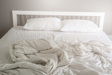 Two white pillow on bed with wrinkle messy blanket in bedroom