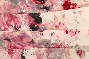 This a photograph of a Red,White,Gray and Black abstract background created using nail polish