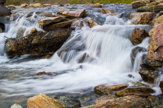 Long exposure picture of a small cold waterfalls through boulders in Snowdonia, Wales