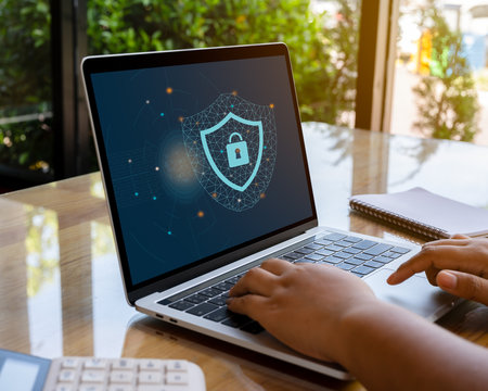 Person using a laptop computer with cyber protection and safe for global network security concept.