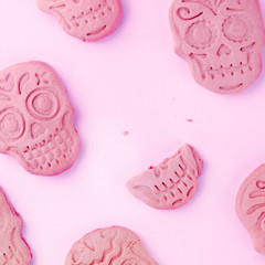 Halloween or Dia de los Muertos square greeting card with skull ginger cookies, shot from the top on a pink background with a place for text