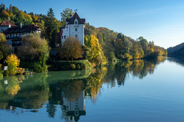 Fototapeta na wymiar old castel at the river in autumn blue sky