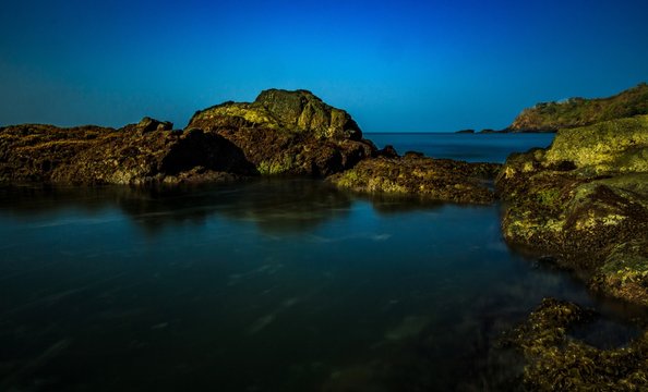beach landscape and rocks with green moss at Pollem, India