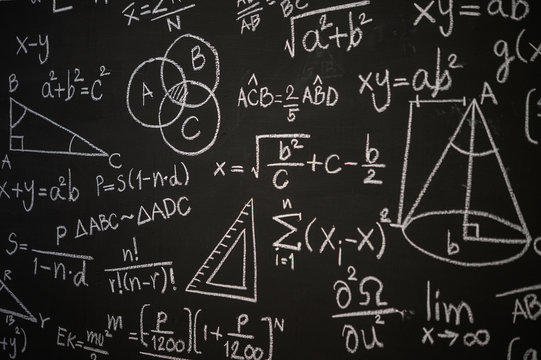 Blackboard inscribed with scientific formulas and calculations in physics, mathematics and electrical circuits. Science and education background.