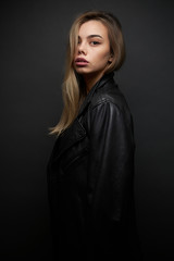 Fashion portrait of a sexy blonde woman with a make up wearing black clothes