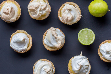 Lemon meringue tarts on black background - top view photo of limes and lime meringues © Madele