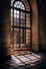 grande fenêtre vitrée, carrelage ancien et une banquette rouge luxueuse 