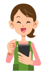 スマートフォンを操作するエプロンを着けた女性の笑顔