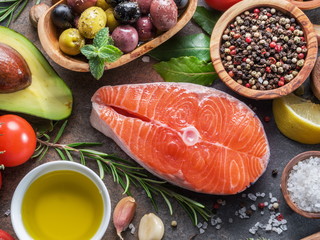 Raw salmon with spices and vegetables on the graphite board.