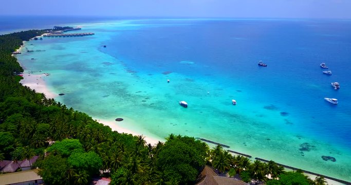 Drone aerial view of a tropical island resort in Ko Lipe island, with turquoise waters, a lagoon, white sand beach and small cruise boats waiting for tourists