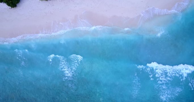 Aerial drone top view of tropical exotic and emerald sandy over wavy island beach in Malaysia