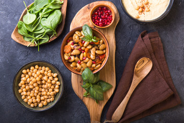 Spicy Chickpea and beans curry Chana Masala in bowl on stone  table. Traditional Indian dish. Top view.