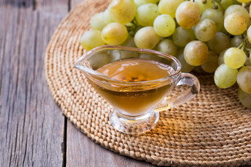 Balsamic vinegar in a glass jug, vintage wooden background, rustic style,