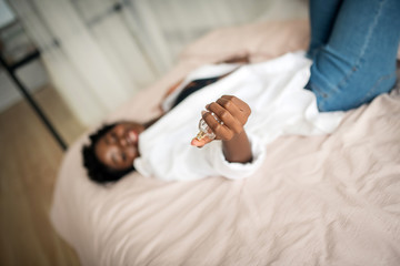 Close up of dark-skinned woman holding perfume