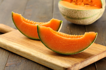 fette di melone giallo con prosciutto sfondo rustico