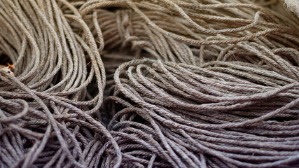 Rough Cord made from natural plant fiber. Rope detail, closeup. Horizontal. Orange and violet duotone. Copy space. Wallpaper and background about fabtic manufacture, eco friendly material. Banner
