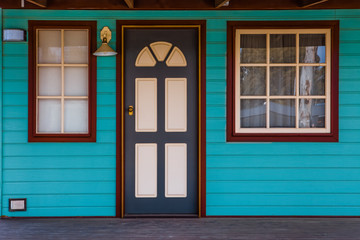 Entrance door and windows into wooden historic cabin