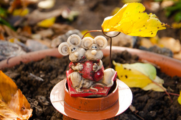 figures of two mice in an autumn garden with leaves