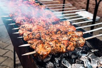 Hot grilled pork kebab or barbecue kebab on charcoal background with herbs and spices closeup....
