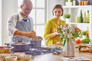Smiling young couple cooking food in the kitchen