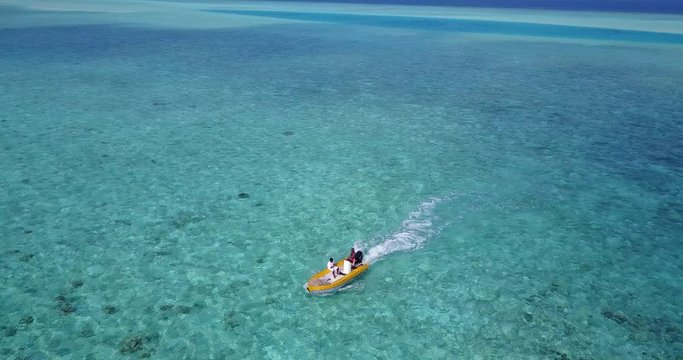 Local fishermen in the small yellow fishing boat in a tropical sea, aerial drone orbiting shot