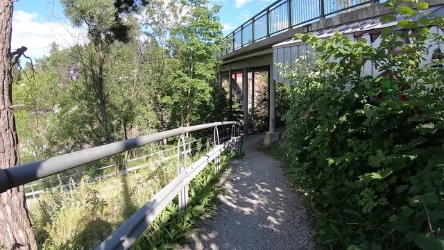 Walking along a pth in a city or town on a warm summer day - Point of View slow motion