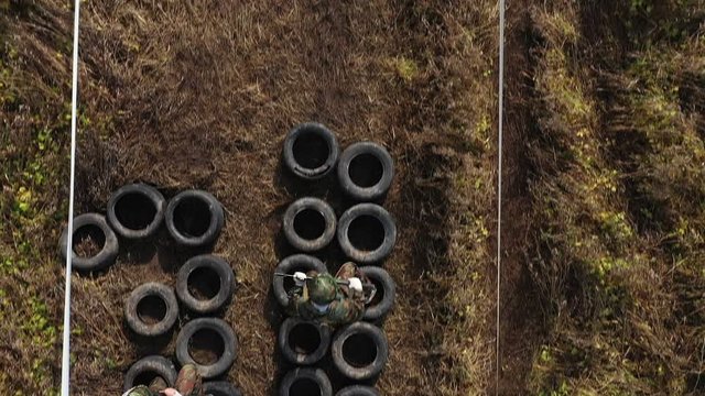 Soldiers pass the obstacle course at the military training. Aerial video. Top view. Drone. Autumn yellow trees