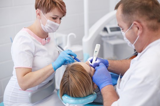 Doctor dentist treats teeth of a beautiful young girl patient. The girl on reception at the dentist. Doctor dentist treats tooth