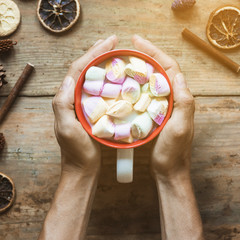 Hand with hot beverage near spices