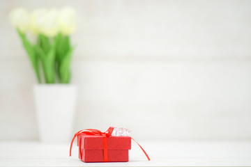 Gift box on the wooden background. Red ribbon. Valentine's Day gift.