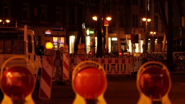 Traffic beacon signs forcing a detour in street at night