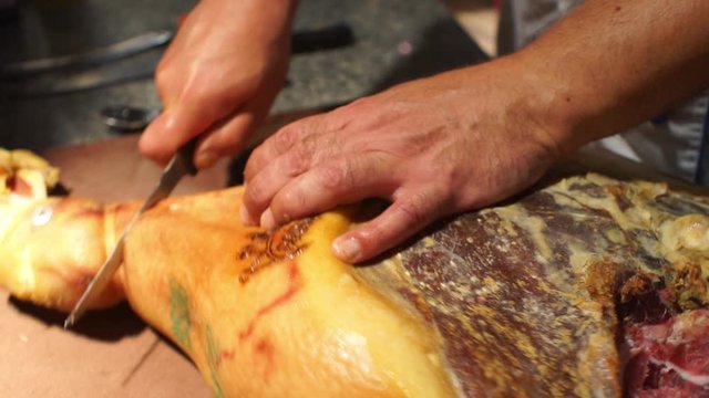 Close up footage of cook preparing a prosciutto