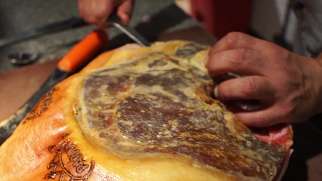 Close up footage of cook preparing a prosciutto