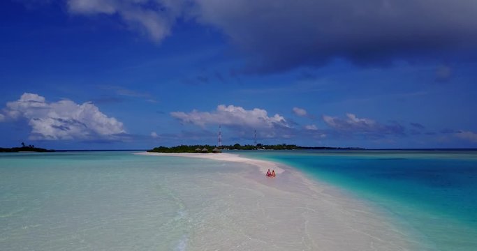 Sumertime romance. Young couple sunbathing on the tropical white beach, sandbank on high tide, Caribbean islands