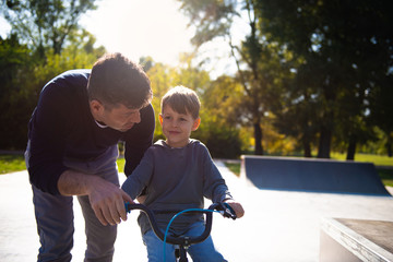 Fototapeta premium Father Learning his son to ride a bicycle