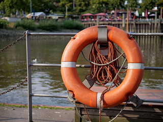 Lifebuoy attached to the harbor wall on a metal railing