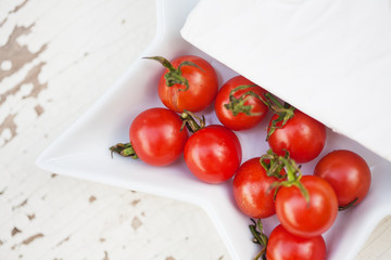 wooden background plate of brie cheese and cherry tomatoes