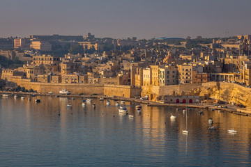 Obraz premium Valletta Panorama of the City Center and Fishing Boats. Beautiful aerial view of the Valletta city in Malta. Taken from a Ship this photo captures well the amazing architecture and charm of this city.