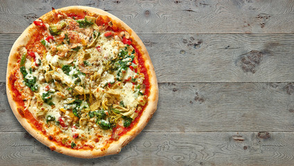 Textured wooden Table with vegetarian pizza.