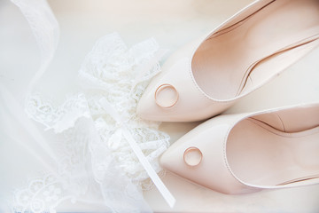 Beautiful bride's wedding shoes, garter and wedding rings