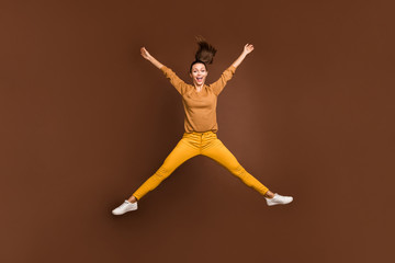 Fototapeta na wymiar Full length body size photo of cheerful positive cute nice sweet pretty girl expressing overjoying emotions jumping in star shape isolated over brown pastel color background
