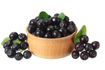 Chokeberry in wooden bowl isolated on white background. Black aronia