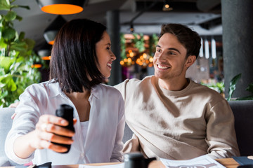 selective focus of happy woman looking at man in sushi bar