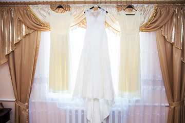 bride and bridesmaids dresses hanging on hangers