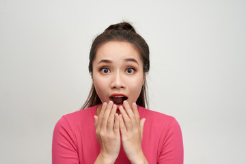 Portrait of amazed young woman over white background