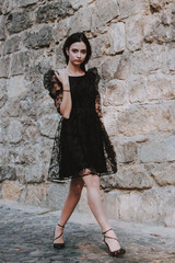 Black-haired girl. Black lace dress. Model shooting. Fashion and style.